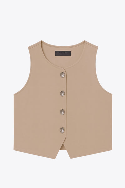 Chaleco corto de fit recto, cuello redondo y cierre frontal con hilera de botones en contraste. Detalle de abertura frontal en bajo.