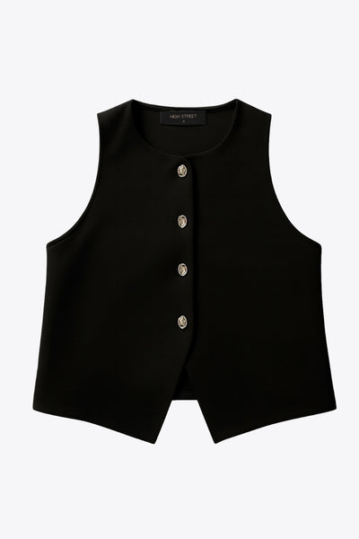 Chaleco corto de fit recto, cuello redondo y cierre frontal con hilera de botones en contraste. Detalle de abertura frontal en bajo.