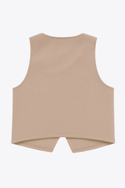 Chaleco corto de fit recto, cuello redondo y cierre frontal con hilera de botones en contraste. Detalle de abertura frontal en bajo.