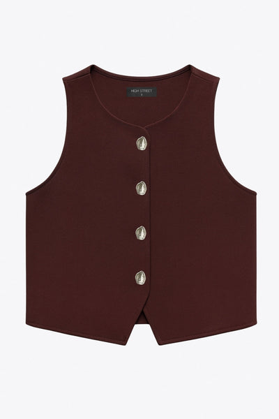Chaleco corto de fit recto, cuello redondo y cierre frontal con hilera de botones en contraste. Detalle de abertura frontal en bajo.