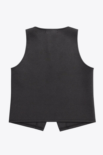 Chaleco corto de fit recto, cuello redondo y cierre frontal con hilera de botones en contraste. Detalle de abertura frontal en bajo.