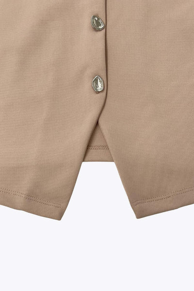 Chaleco corto de fit recto, cuello redondo y cierre frontal con hilera de botones en contraste. Detalle de abertura frontal en bajo.