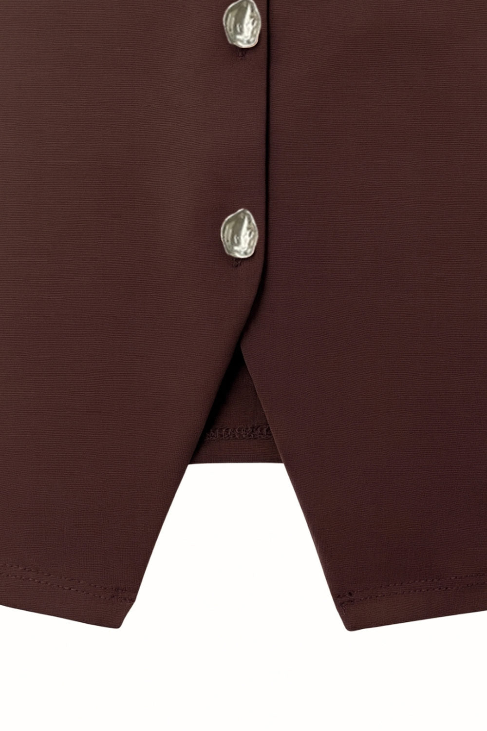 Chaleco corto de fit recto, cuello redondo y cierre frontal con hilera de botones en contraste. Detalle de abertura frontal en bajo.