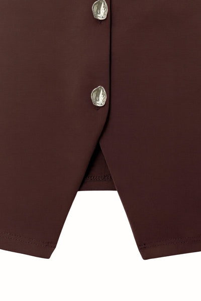 Chaleco corto de fit recto, cuello redondo y cierre frontal con hilera de botones en contraste. Detalle de abertura frontal en bajo.