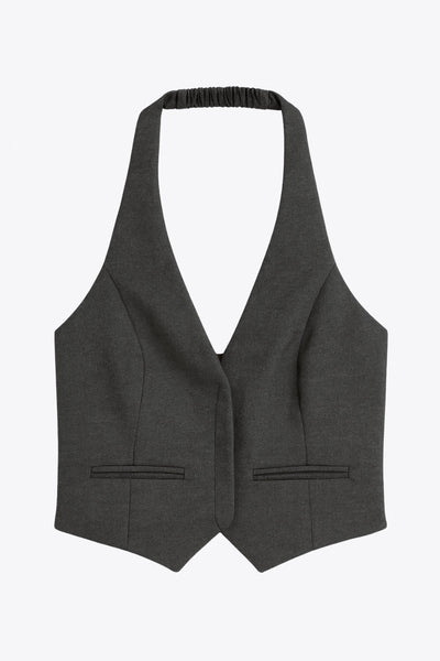 Chaleco corto cuello halter, fit ajustado, escote v, cierre frontal con hilera oculta de botones, vivos decorativos frontales y bajo v frontal. Escote en espalda y detalle de trabilla ajustable posterior.