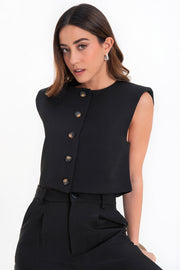 Chaleco corto de fit recto, cuello redondo, con hombreras y cierre frontal con hilera de botones en contraste.