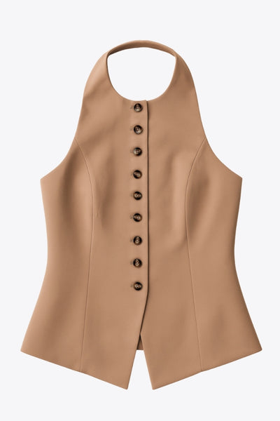 Chaleco corto halter, de fit ajustado, cuello redondo, cierre frontal con hilera oculta de botones, en contraste, pinzas frontales y abertura en bajo. Detalle de escote en espalda.
