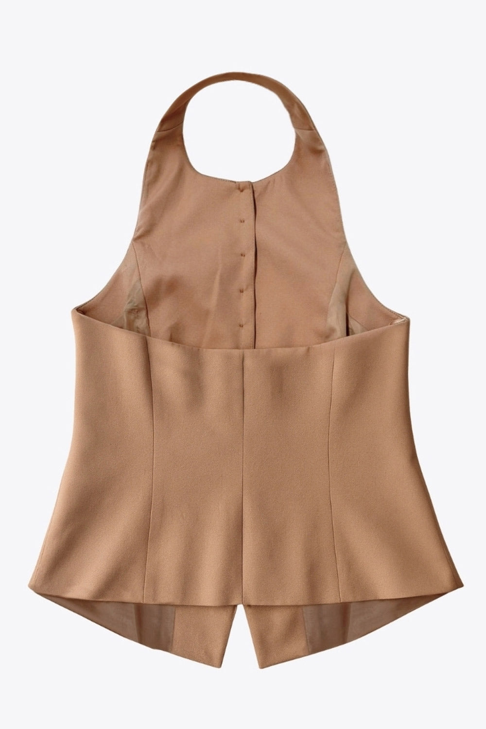 Chaleco corto halter, de fit ajustado, cuello redondo, cierre frontal con hilera oculta de botones, en contraste, pinzas frontales y abertura en bajo. Detalle de escote en espalda.