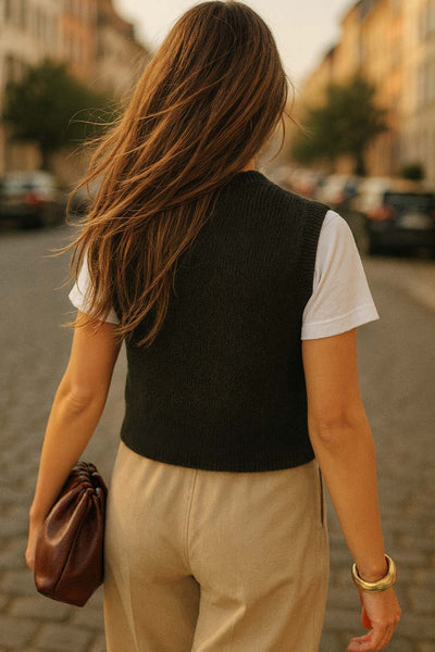 Chaleco corto de punto, fit recto, bolsillos frontales con botón, rib en puños, bajo y cuello redondo. Cierre frontal con hilera de botones en contraste.