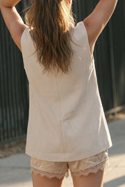 Chaleco largo recto de fit oversized, cuello solapa, cruce frontal en diagonal, vivos frontales y cierre con botón en contraste.