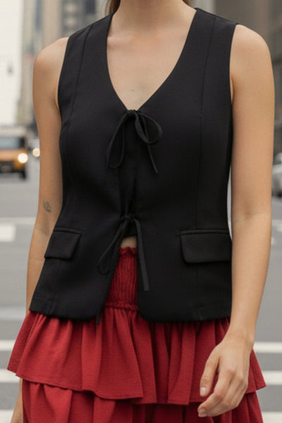 Chaleco de fit recto, escote v redondeado, pinzas frontales, bolsillos delanteros con cartera y cierre frontal con lazado amarrable.