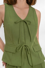 Chaleco de fit recto, escote v redondeado, pinzas frontales, bolsillos delanteros con cartera y cierre frontal con lazado amarrable.