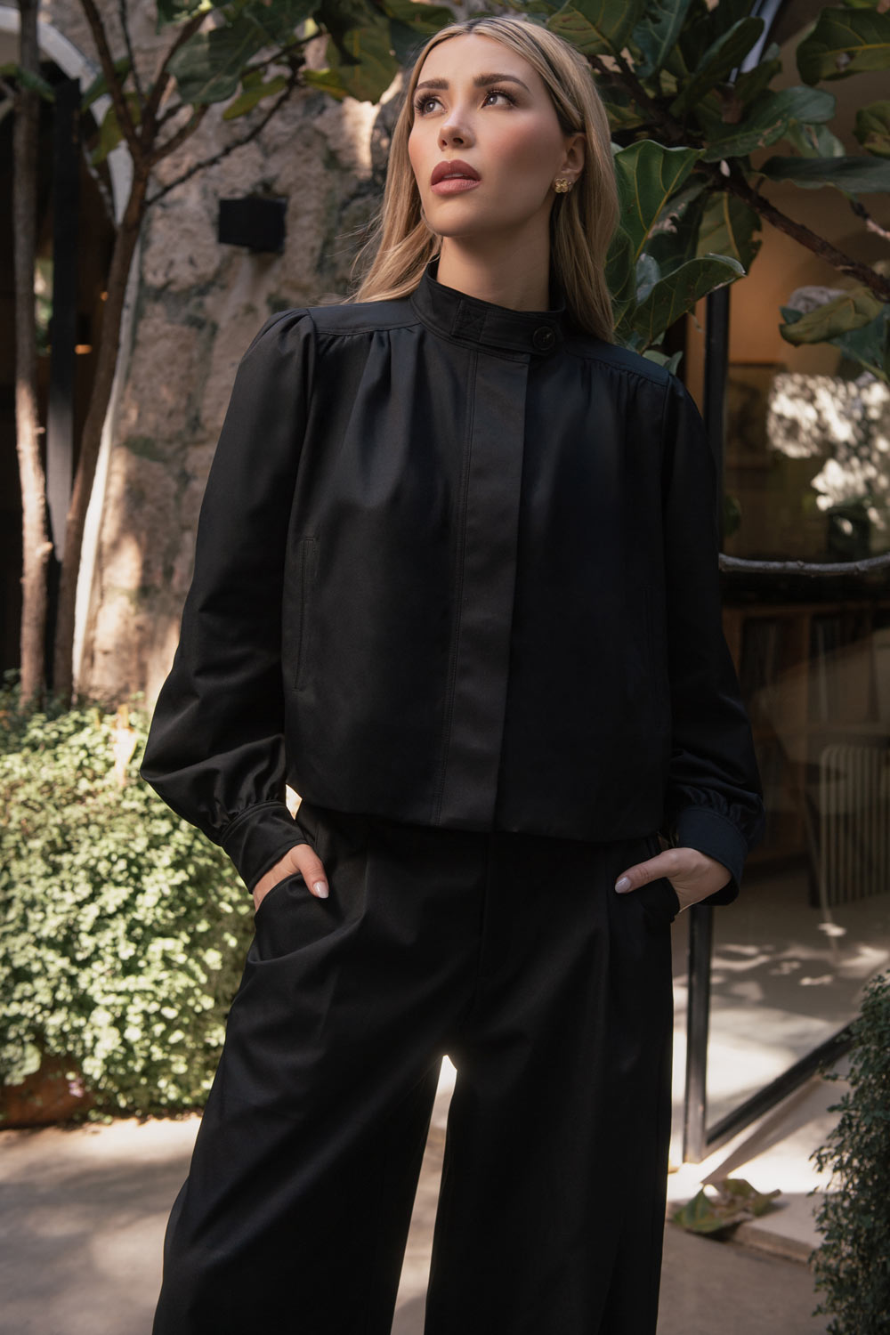 Chamarra corta de fit abullonado, cuello alto, manga larga abullonada con puño abotonado y cierre frontal con cremallera oculta. Detalle de plisados decorativos frontales y trabillas con botón en cuello.