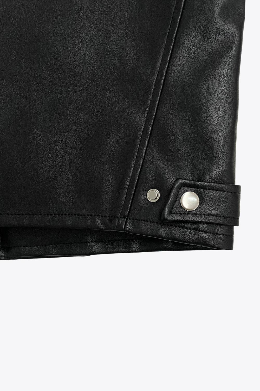 Chamarra corta tipo biker de efecto piel, fit recto, manga larga, con cuello y botones en contraste. Detalle de bolsillos frontales verticales con cremallera y franjas decorativas en contraste. Cierre frontal con cremallera.