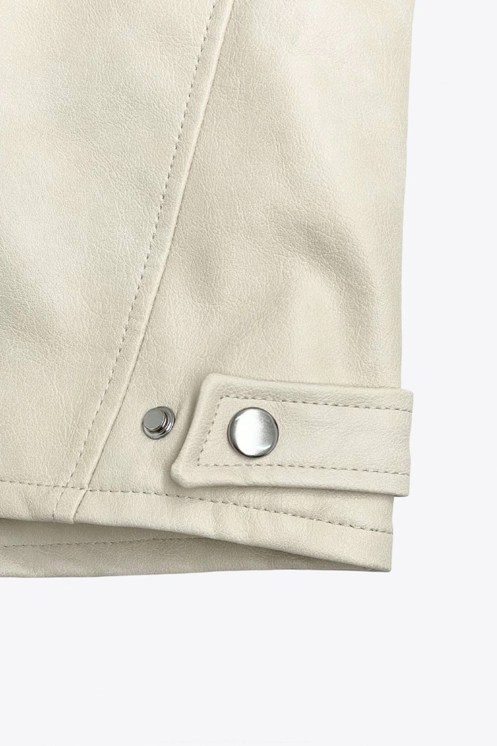 Chamarra corta tipo biker de efecto piel, fit recto, manga larga, con cuello y botones en contraste. Detalle de bolsillos frontales verticales con cremallera y franjas decorativas en contraste. Cierre frontal con cremallera.