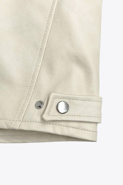 Chamarra corta tipo biker de efecto piel, fit recto, manga larga, con cuello y botones en contraste. Detalle de bolsillos frontales verticales con cremallera y franjas decorativas en contraste. Cierre frontal con cremallera.