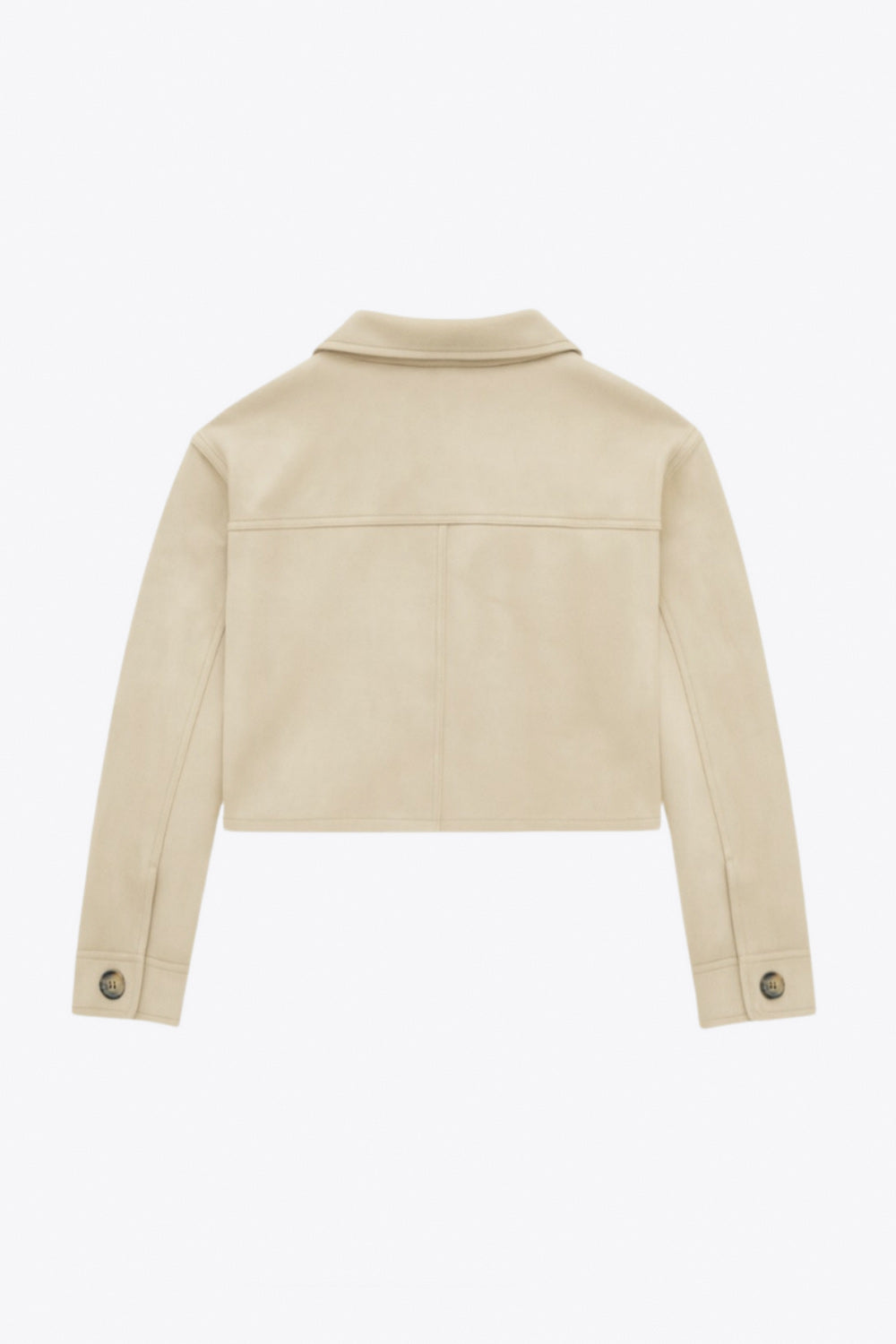 Chamarra corta fluida de gamuza, manga larga con puño abotonado, cuello camisero, bolsillos frontales de parche y cierre frontal con hilera de botones en contraste.