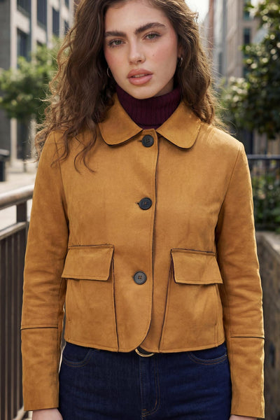 Chamarra corta de fit recto, manga larga con cortes decorativos, cuello camisero con detalle curveado, bolsillos frontales con cartera y cierre frontal con hilera de botones en contraste.