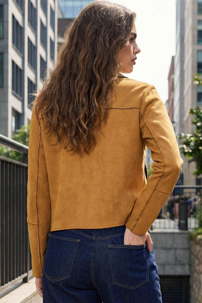 Chamarra corta de fit recto, manga larga con cortes decorativos, cuello camisero con detalle curveado, bolsillos frontales con cartera y cierre frontal con hilera de botones en contraste.