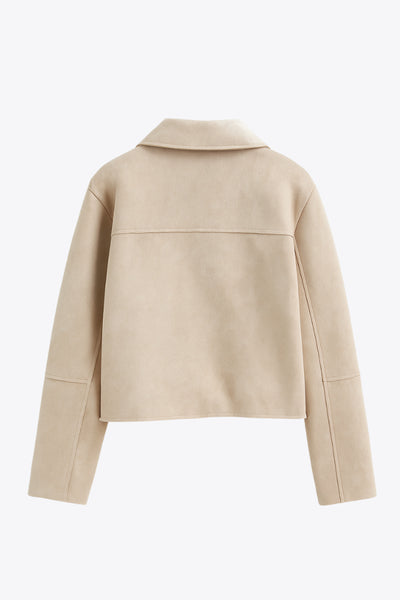 Chamarra corta de fit recto, manga larga con cortes decorativos, cuello camisero con detalle curveado, bolsillos frontales con cartera y cierre frontal con hilera de botones en contraste.