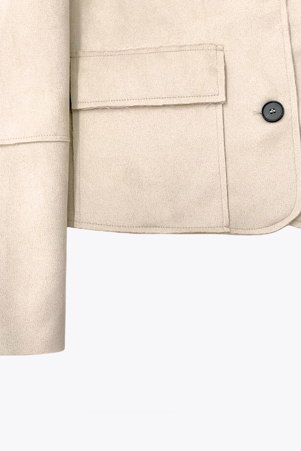 Chamarra corta de fit recto, manga larga con cortes decorativos, cuello camisero con detalle curveado, bolsillos frontales con cartera y cierre frontal con hilera de botones en contraste.