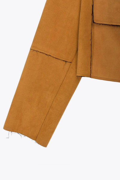 Chamarra corta de fit recto, manga larga con cortes decorativos, cuello camisero con detalle curveado, bolsillos frontales con cartera y cierre frontal con hilera de botones en contraste.