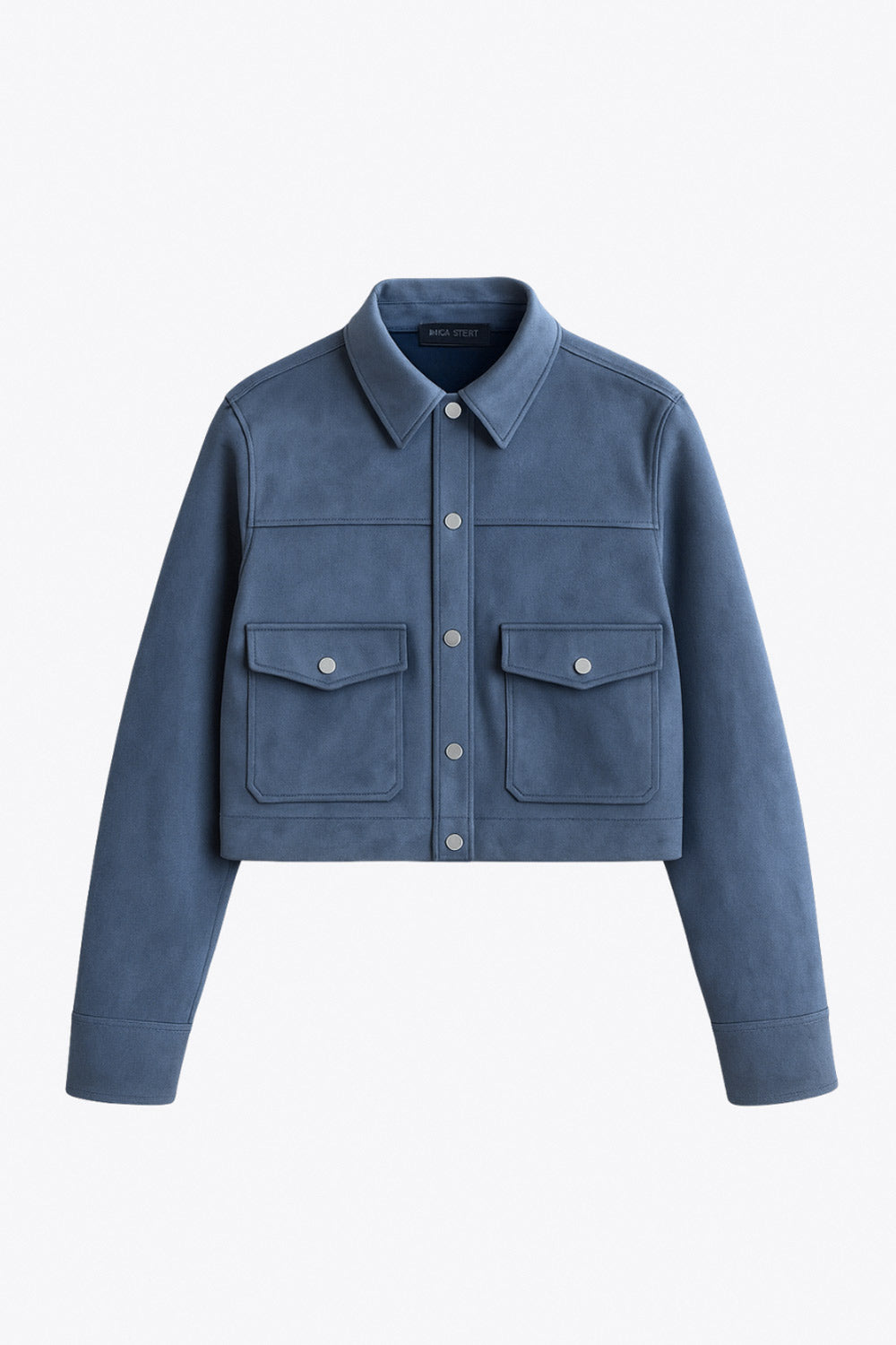 Chamarra corta de gamuza, fit recto, manga larga con puño abotonado, cuello camisero, bolsillos delanteros de parche con cartera y botones de presión. Cierre frontal con hilera de botones en contraste.