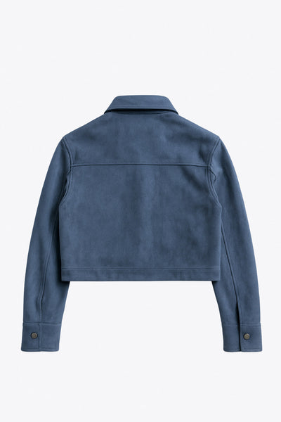 Chamarra corta de gamuza, fit recto, manga larga con puño abotonado, cuello camisero, bolsillos delanteros de parche con cartera y botones de presión. Cierre frontal con hilera de botones en contraste.