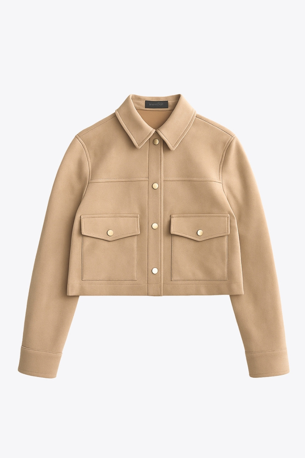 Chamarra corta de gamuza, fit recto, manga larga con puño abotonado, cuello camisero, bolsillos delanteros de parche con cartera y botones de presión. Cierre frontal con hilera de botones en contraste.