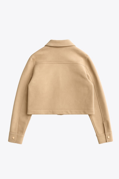 Chamarra corta de gamuza, fit recto, manga larga con puño abotonado, cuello camisero, bolsillos delanteros de parche con cartera y botones de presión. Cierre frontal con hilera de botones en contraste.