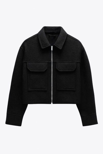 Chamarra corta de borreguillo, fit recto, manga larga con puño abotonado, cuello solapa, bolsillos frontales de parche con cartera y cierre frontal con cremallera visible en contraste.