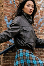 Chamarra de efecto piel, fit oversized, manga larga con puño abotonado, cuello alto, bolsillos delanteros con cartera, cortes decorativos y pretina elástica. Cierre frontal con cremallera oculta.