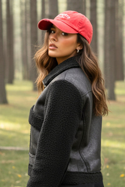 Chamarra corta de efecto piel, interior, mangas y cuello solapa de borreguillo, bolsillos delanteros de parche con detalle en contraste, fit recto, manga larga, costuras decorativas y cierre frontal con cremallera en contraste. Detalle de trabilla decorativa con hebilla en cuello.