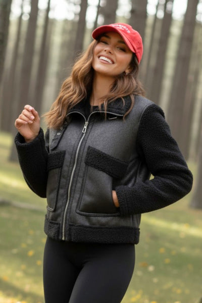 Chamarra corta de efecto piel, interior, mangas y cuello solapa de borreguillo, bolsillos delanteros de parche con detalle en contraste, fit recto, manga larga, costuras decorativas y cierre frontal con cremallera en contraste. Detalle de trabilla decorativa con hebilla en cuello.