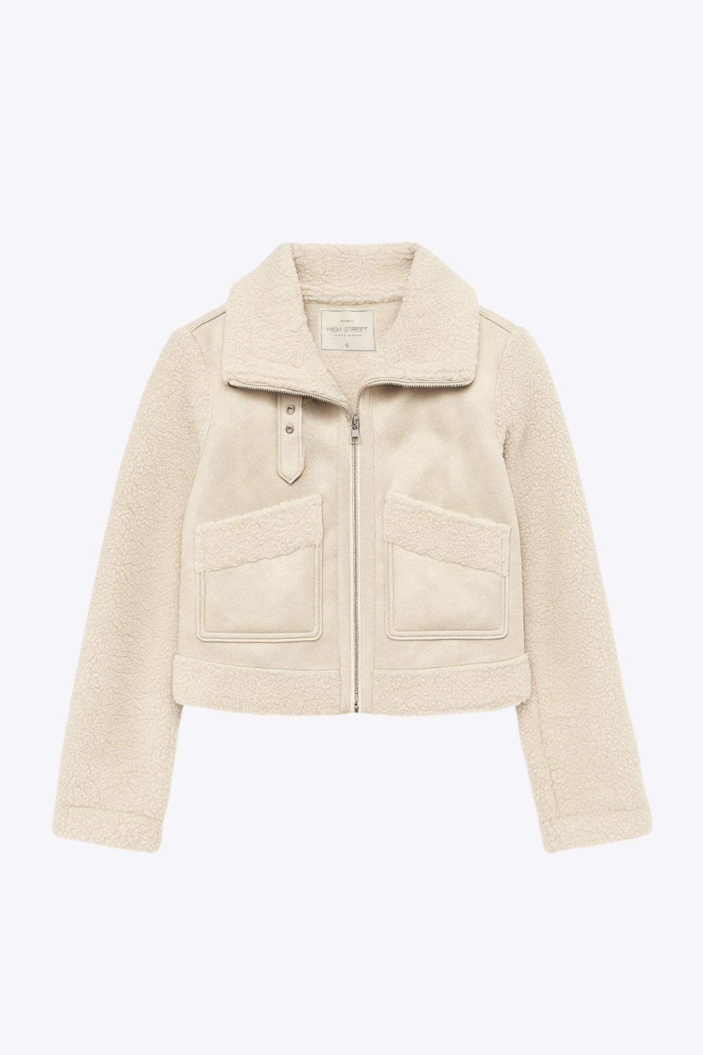 Chamarra corta de efecto piel, interior, mangas y cuello solapa de borreguillo, bolsillos delanteros de parche con detalle en contraste, fit recto, manga larga, costuras decorativas y cierre frontal con cremallera en contraste. Detalle de trabilla decorativa con hebilla en cuello.