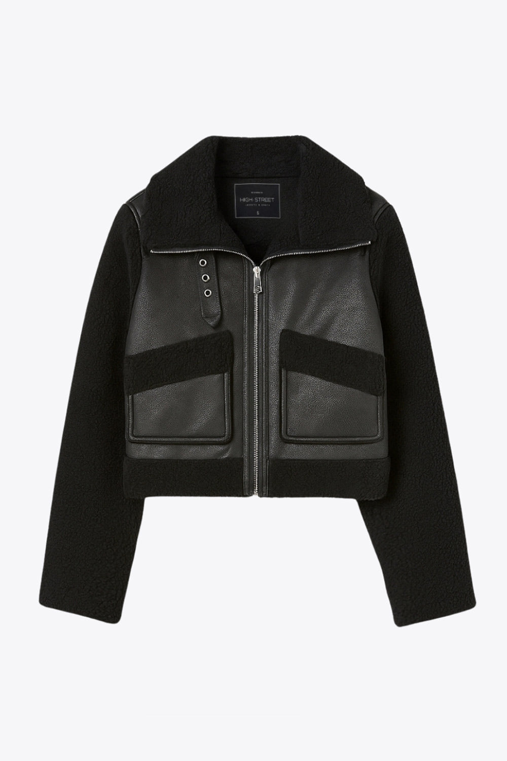Chamarra corta de efecto piel, interior, mangas y cuello solapa de borreguillo, bolsillos delanteros de parche con detalle en contraste, fit recto, manga larga, costuras decorativas y cierre frontal con cremallera en contraste. Detalle de trabilla decorativa con hebilla en cuello.