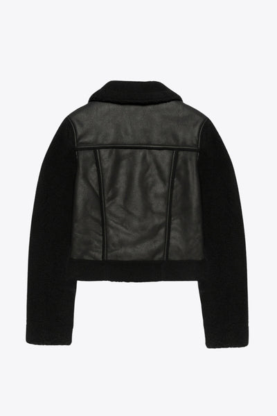 Chamarra corta de efecto piel, interior, mangas y cuello solapa de borreguillo, bolsillos delanteros de parche con detalle en contraste, fit recto, manga larga, costuras decorativas y cierre frontal con cremallera en contraste. Detalle de trabilla decorativa con hebilla en cuello.