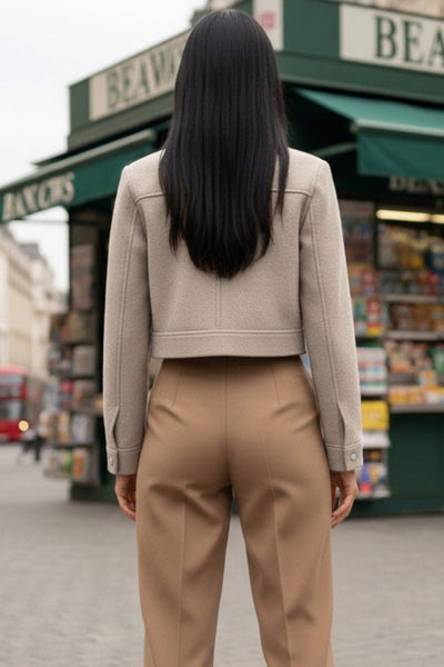 Chamarra corta de fit recto, manga larga con puño abotonado, cuello camisero, bolsillos delanteros de parche con cartera y cierre frontal con cremallera visible en contraste.