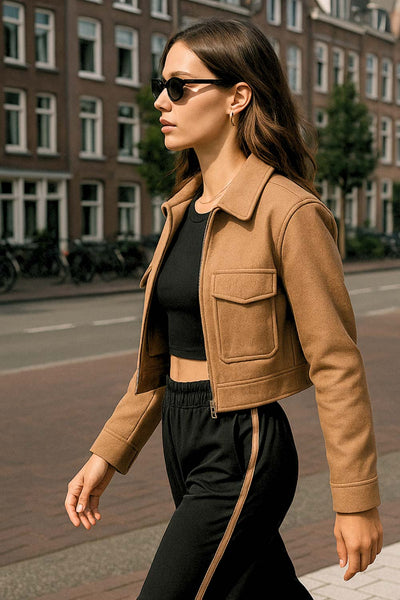 Chamarra corta de fit recto, manga larga con puño abotonado, cuello camisero, bolsillos delanteros de parche con cartera y cierre frontal con cremallera visible en contraste.