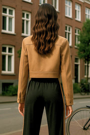 Chamarra corta de fit recto, manga larga con puño abotonado, cuello camisero, bolsillos delanteros de parche con cartera y cierre frontal con cremallera visible en contraste.