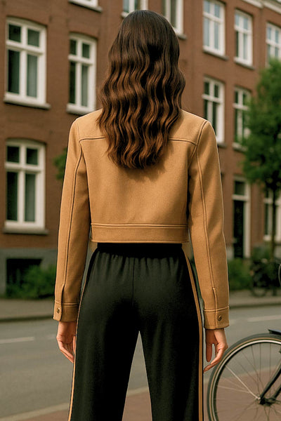 Chamarra corta de fit recto, manga larga con puño abotonado, cuello camisero, bolsillos delanteros de parche con cartera y cierre frontal con cremallera visible en contraste.