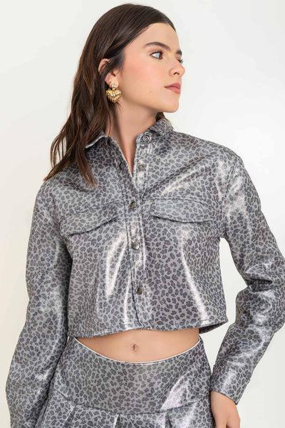 Chamarra corta de estampado animal, fit recto, manga larga con puño abotonado, cuello camisero, bolsillos delanteros decorativos con cartera y cierre frontal con hilera de botones. Detalle de efecto metalizado en tejido.