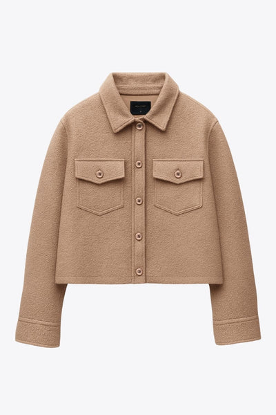 Chamarra corta de borreguillo, manga larga con puño abotonado, cuello solapa, bolsillos frontales de parche con cartera y botón. Cierre frontal con hilera de botones.