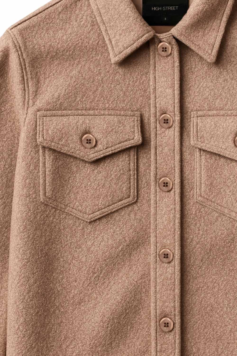 Chamarra corta de borreguillo, manga larga con puño abotonado, cuello solapa, bolsillos frontales de parche con cartera y botón. Cierre frontal con hilera de botones.