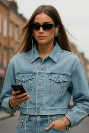 Chamarra corta de denim, fit ligeramente oversized, manga larga con puño abotonado, cuello clásico, bolsillos frontales con cartera y botón en contraste. Cierre frontal con hilera de botones en contraste.