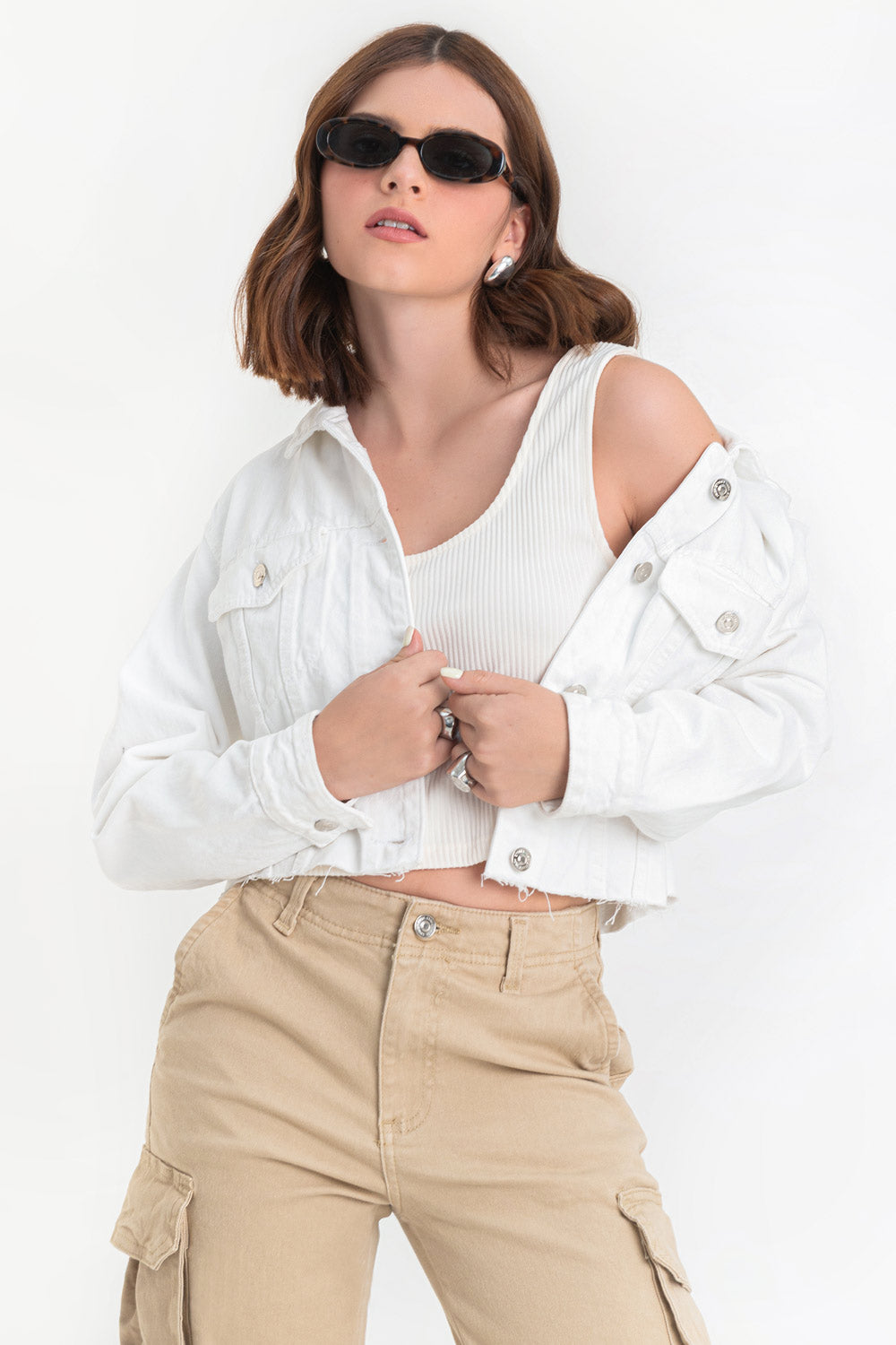 Chamarra corta de denim, fit recto y manga larga con puños abotonados. Cuello clásico, bolsillos delanteros con cartera y botón en contraste. Cierre frontal con hilera de botones en contraste y detalle de rotos en bajo.