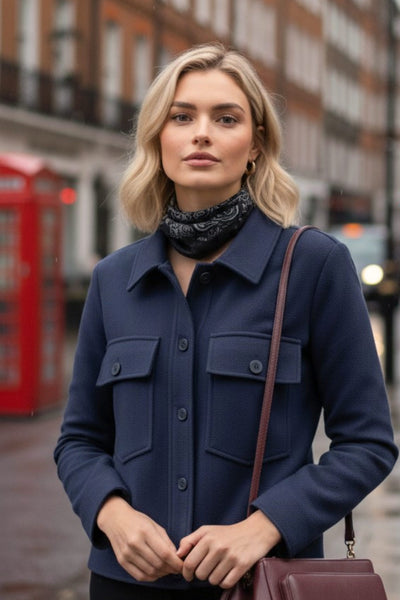 Chamarra corta de fit recto, cuello camisero, manga larga con puño abotonado, bolsillos delanteros de parche con cartera y botón en contraste. Cierre frontal con hilera de botones en contraste.
