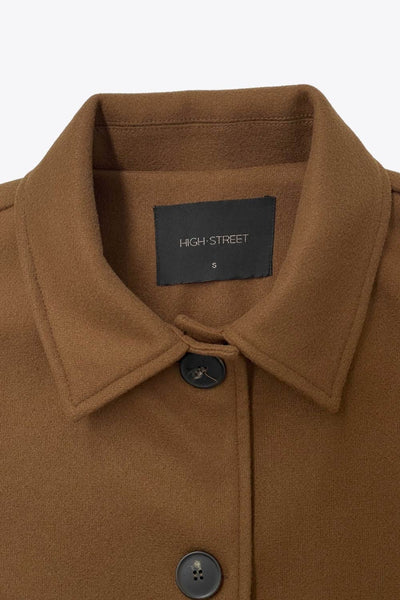 Chamarra corta de fit recto, manga larga con puño abotonado, cuello solapa, bolsillos delanteros con vivos y cierre frontal con hilera de botones en contraste.