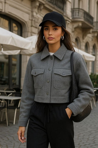 Chamarra corta de fit recto, manga larga con puño abotonado, cuello camisero, bolsillos delanteros de parche con cartera y cierre frontal con hilera de botones.