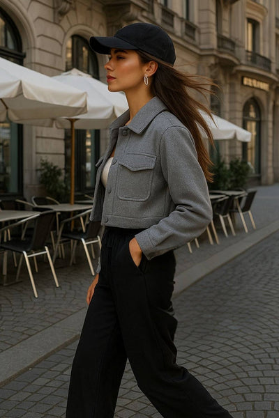 Chamarra corta de fit recto, manga larga con puño abotonado, cuello camisero, bolsillos delanteros de parche con cartera y cierre frontal con hilera de botones.